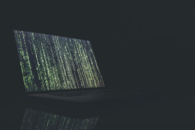 Dark illustration of cascading green code on a laptop screen, symbolizing cybersecurity and on-device threat detection